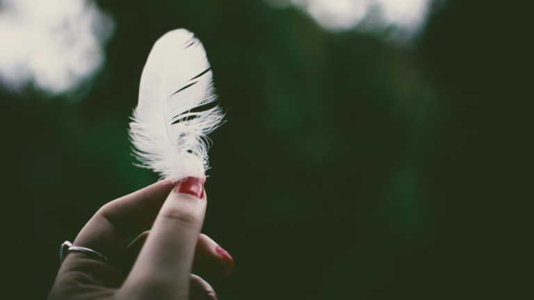 Hand mit Feder in der Hand
